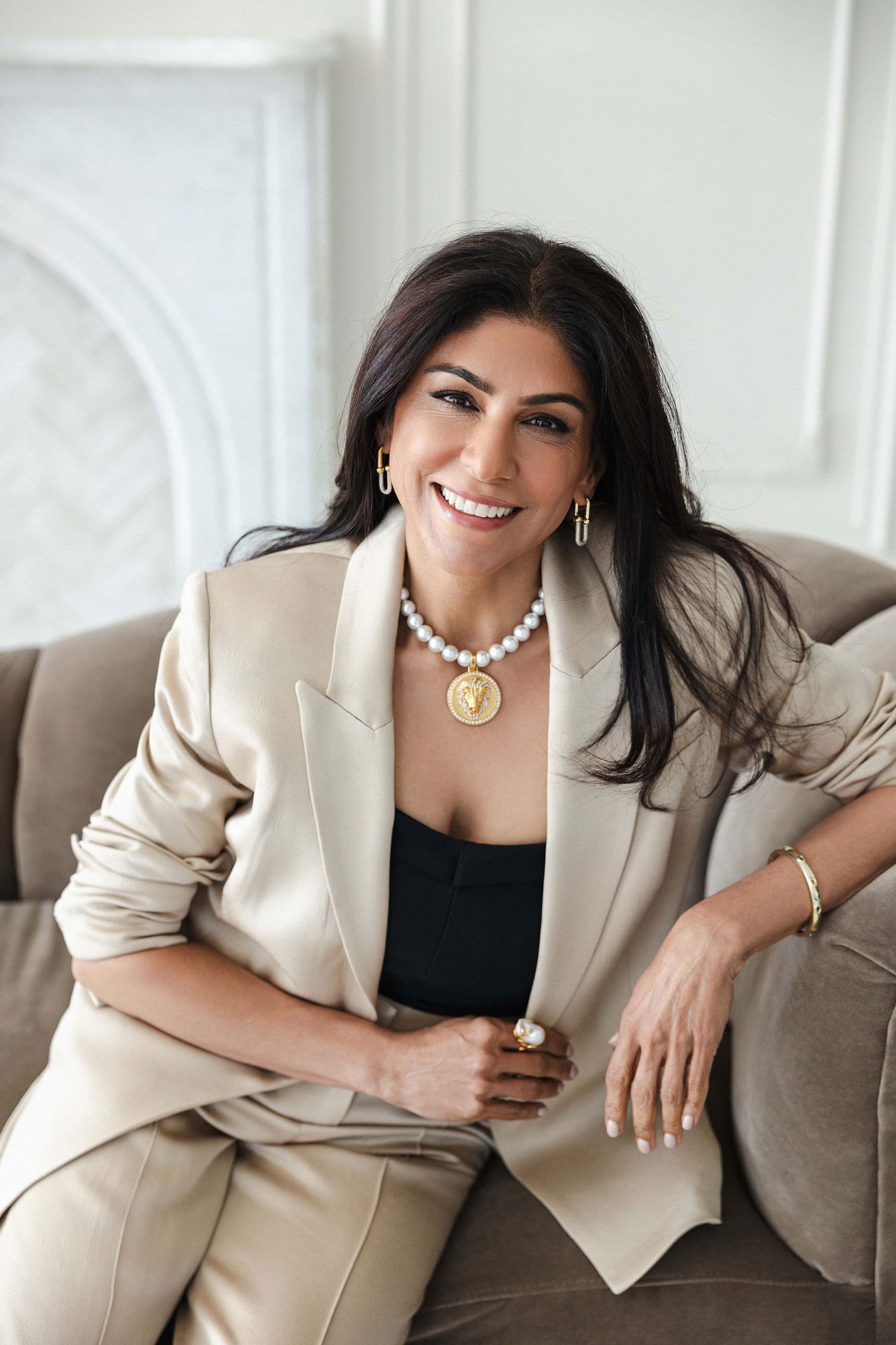 Gauri Chawla seated in a light suit and smiling at the camera